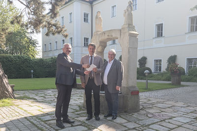 Vorsitzender des Trägervereins Christian Kalis (links) und Abt Hermann Josef Kugler (rechts) übergaben die neue Fassung der Satzung des Trägervereins an Bezirkstagspräsident Dr. Olaf Heinrich.