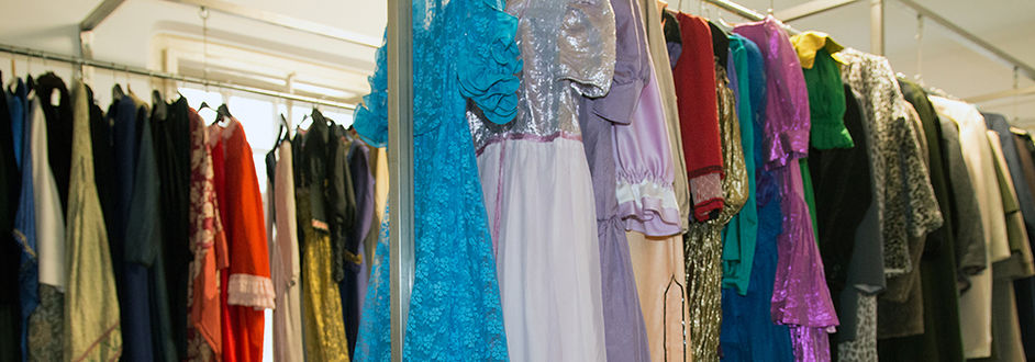 Eine Vielzahl an Kostümen für unterschiedlichste Theaterstücke auf Kleiderstangen.